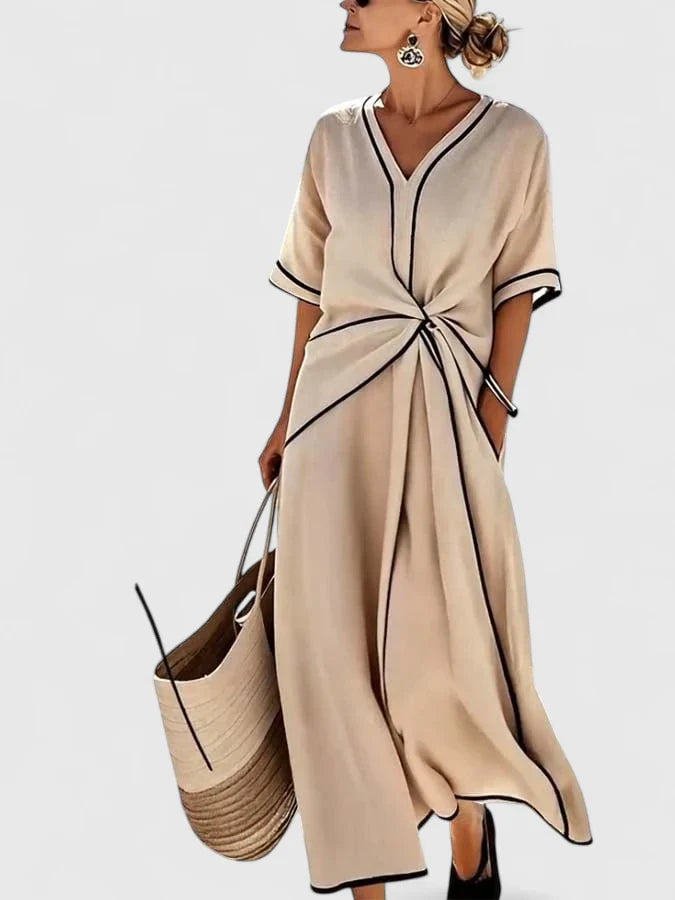 Kobieta w eleganckiej sukience maxi na lato z dekoltem w serek i kontrastową lamówką