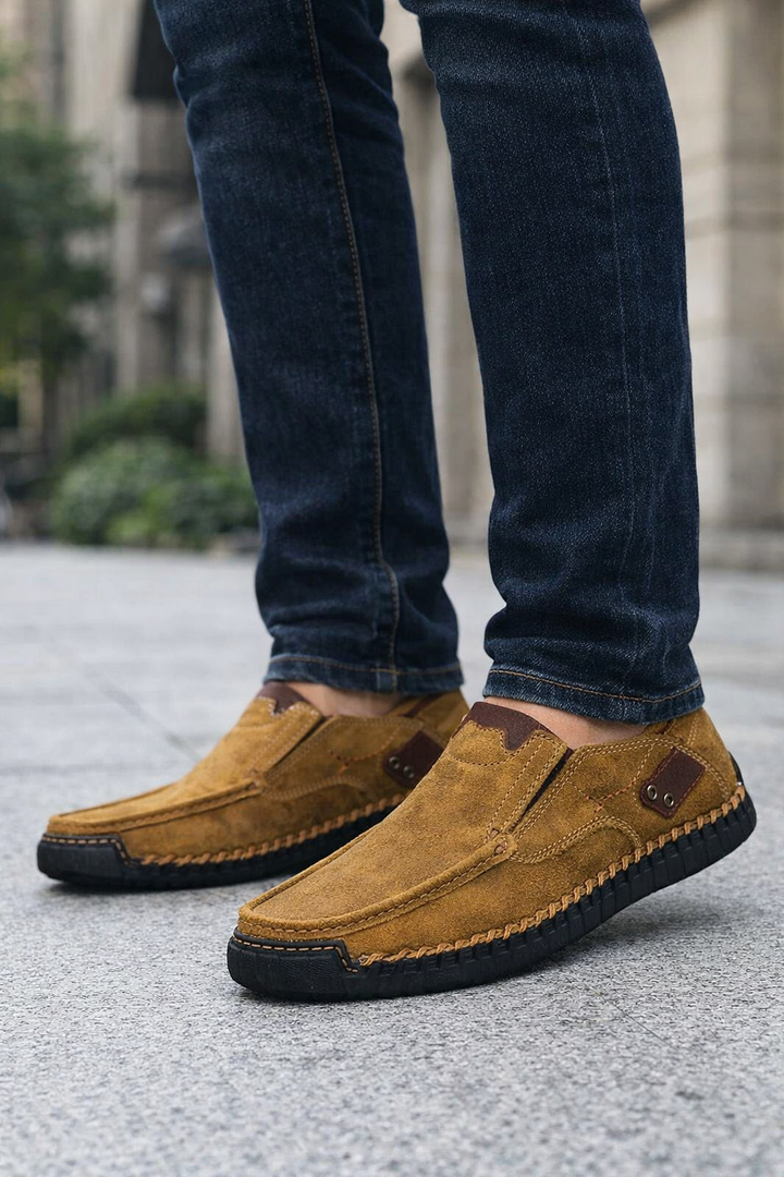 Buty Męskie Wsuwane Z Przeszyciami w kolorze brązowym z kontrastowym panelem bocznym i rowkowaną podeszwą na modelu w dżinsach