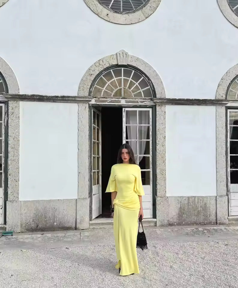 Kobieta w eleganckiej żółtej sukience maxi z szerokim rękawem