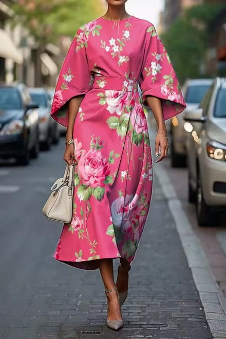 Detal szerokich rękawów typu kimono sukienki midi, kwiatowy wzór w odcieniach różu i zieleni, luźny zwiewny krój