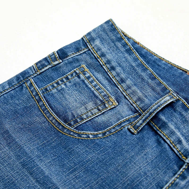 Detale tylnych kieszeni spodenek jeansowych męskich z kontrastowym przeszyciem i patch skórzany