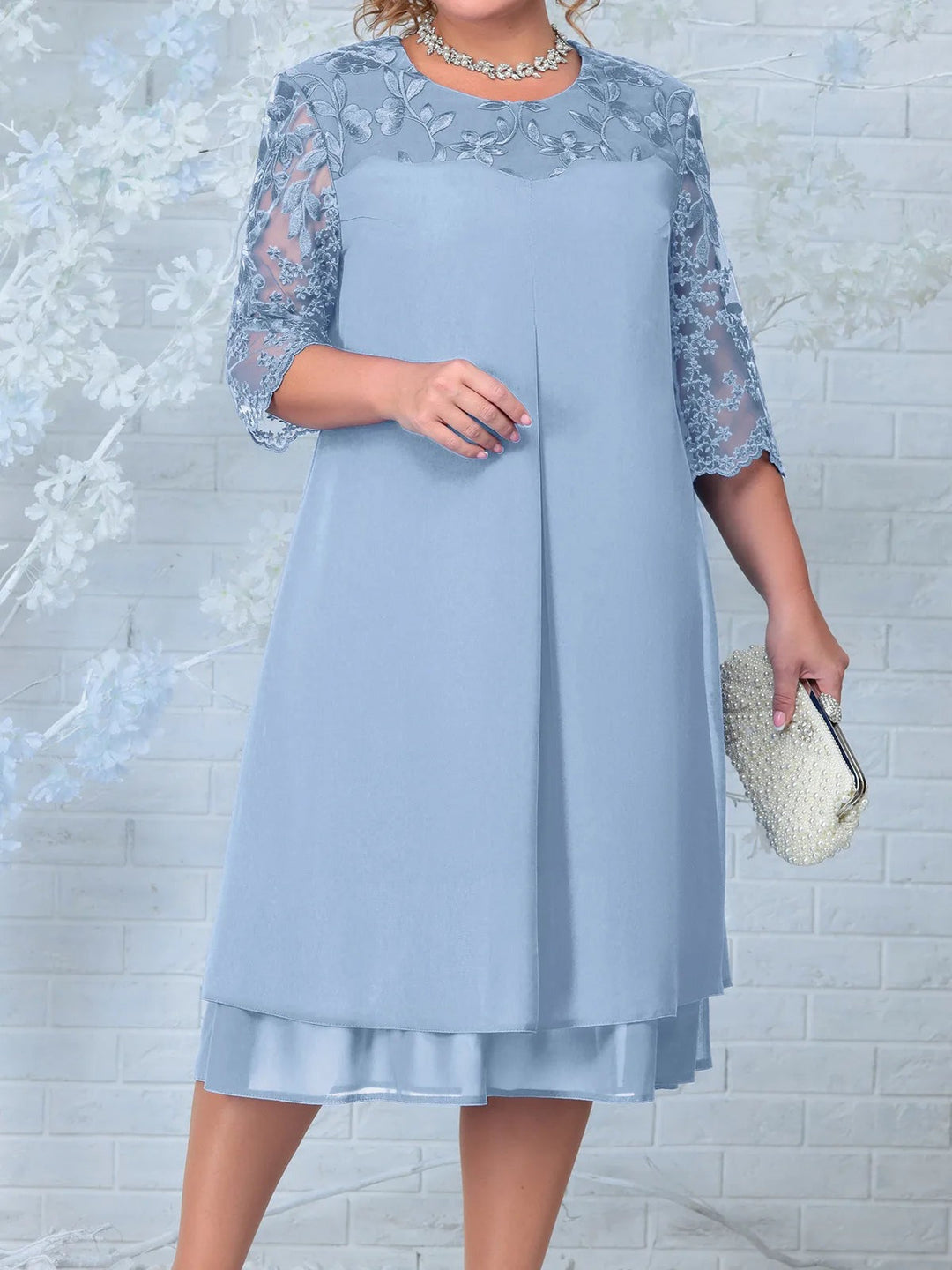 Detal haftowanych rękawów sukienki plus size z transparentną siatką i motywami floralnymi