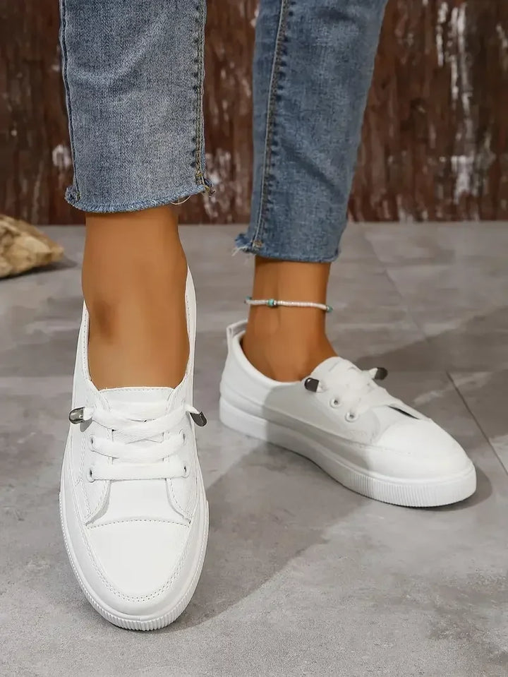 Białe sneakersy damskie sznurowane z metalowymi zakończeniami sznurowadeł i panelami przeszyciowymi na cholewce