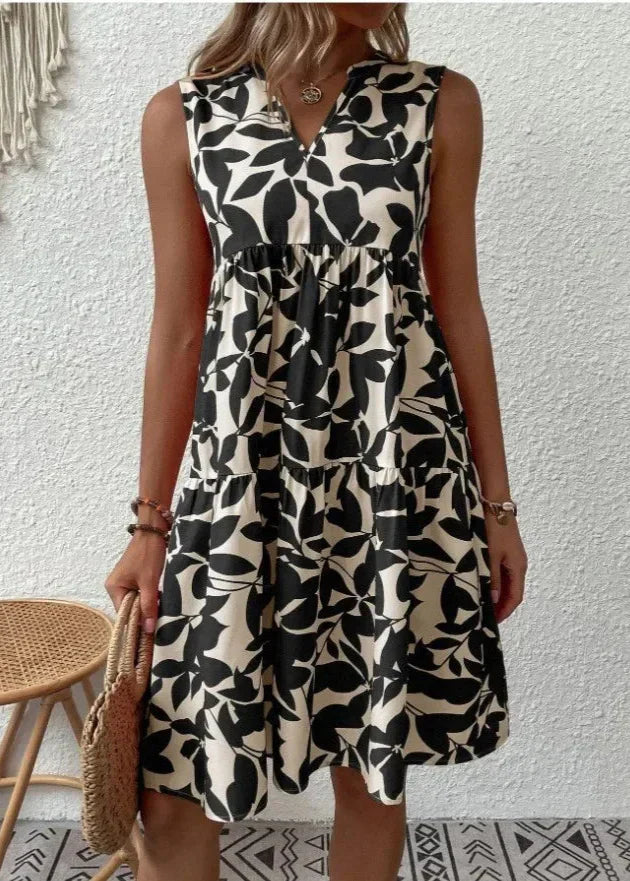Elegancka sukienka letnia bez rękawów z elastyczną talią i romantycznymi falbanami w kolorowy print