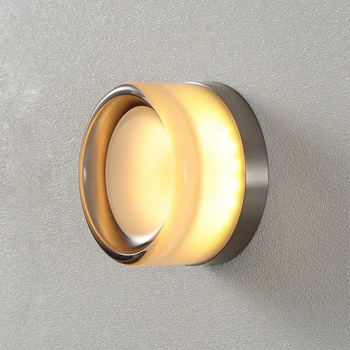 Kinkiet LED w designerskiej oprawie z aluminium i akrylu o wymiarach 7,5×13,5 cm na białej ścianie